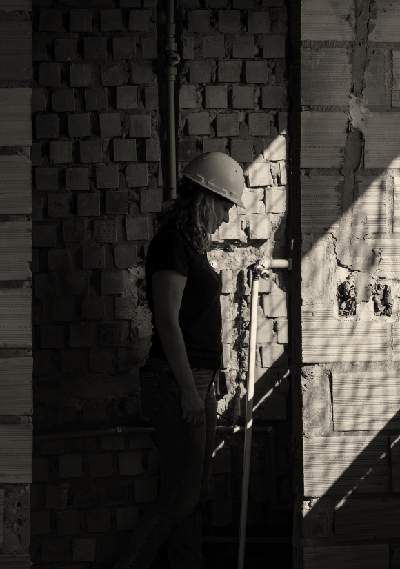 Arquiteta Letícia entre paredes de alvenaria do apartamento em obras no Mansa.