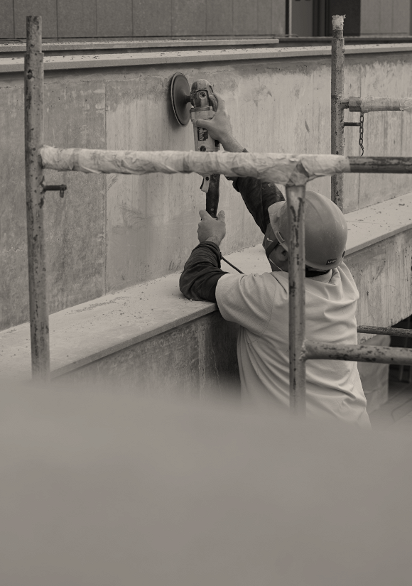 Homem trabalhando no polimento do concreto aparente.